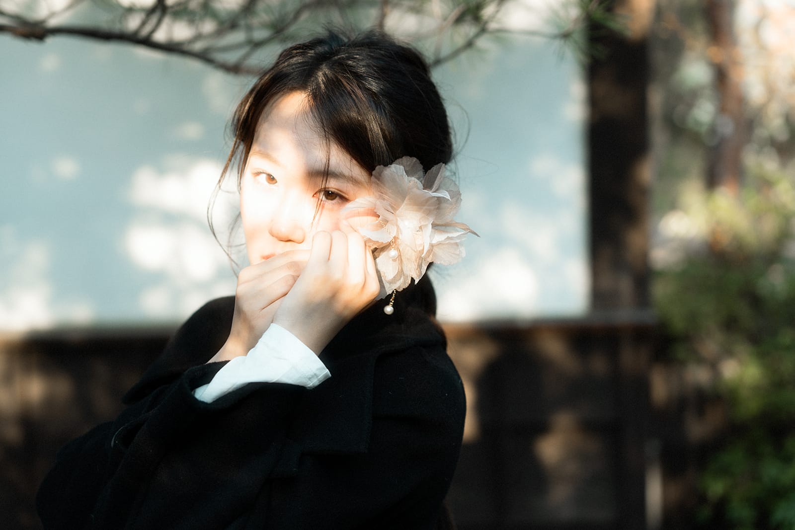 Portrait of a woman with a white flower in her hair, warm afternoon light